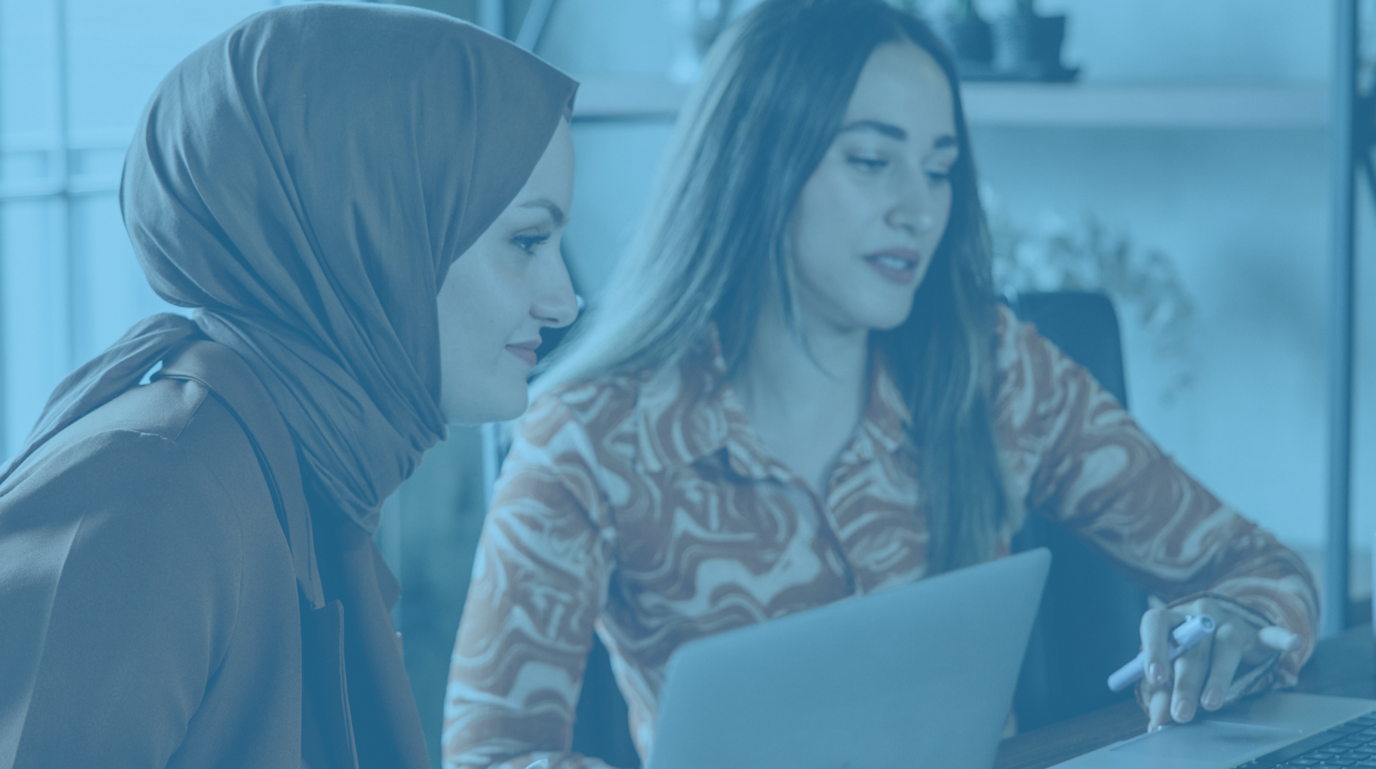 Two women looking at a laptop